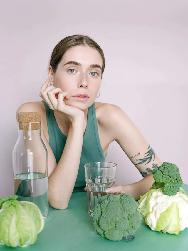 Surprised woman looking in mirror with keto-friendly foods on counter.