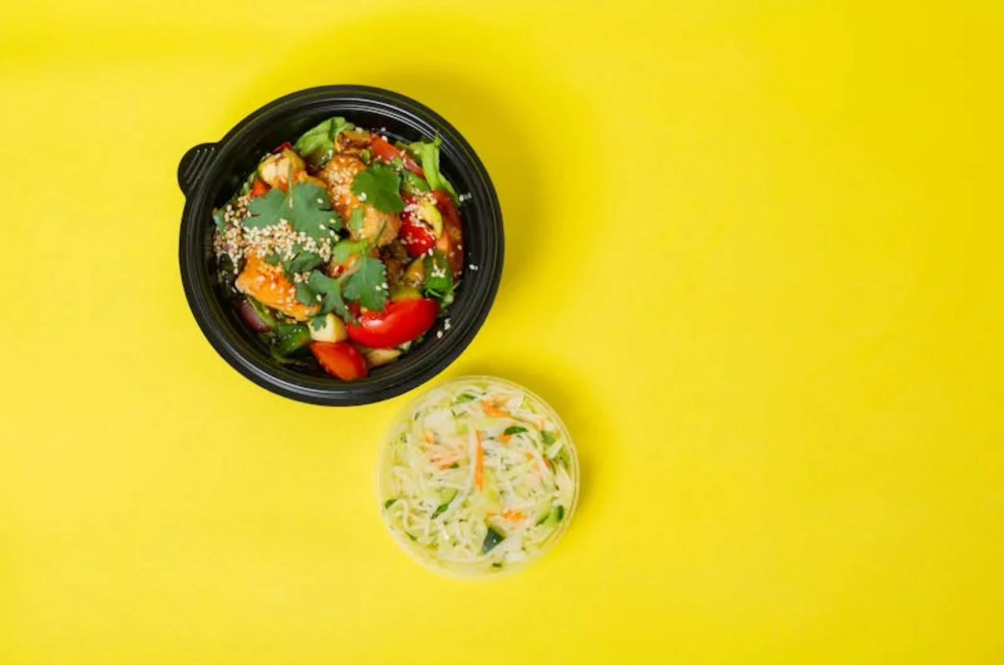 Top view of keto-friendly foods including avocado, eggs, salmon, leafy greens, nuts, and olive oil arranged on a wooden table — ideal for a low-carb diet.
